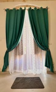 uma cortina verde e um tapete em frente a uma janela em Al Barocco em Sortino