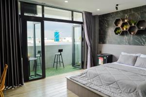 a bedroom with a large bed and a balcony at Cherry Hotel Bến Lức in Bến Lức