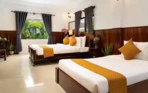 um quarto de hotel com duas camas e uma janela em The Urban em Siem Reap