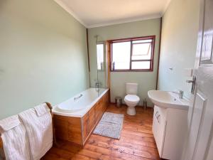 a bathroom with a tub and a toilet and a sink at Porcupine Cabin in Palatswe