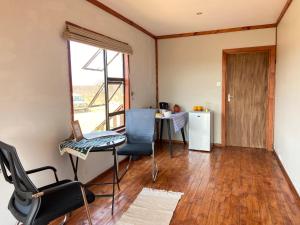 ein Wohnzimmer mit einem Tisch, Stühlen und einem Fenster in der Unterkunft Porcupine Cabin in Palatswe