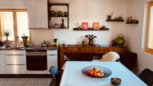 eine Küche mit einem Tisch und einem Obstteller darauf in der Unterkunft Le Lézard et la Grenouille BnB in Ovronnaz
