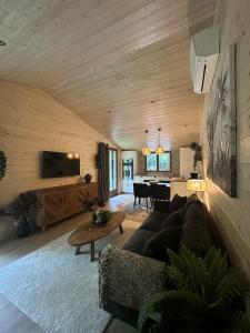 a living room with a couch and a table at Le chalet du lys avec bain scandinave Insolys in Gouvieux