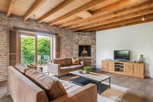 sala de estar con sofá y chimenea en Authentic vacation home 'De Blauwe Kroon' en Oostkamp