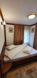 duże łóżko w pokoju z oknem w obiekcie Pensiunea Cota 1200 Piscul Negru w mieście Arefu