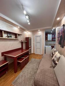 ein Wohnzimmer mit einem Sofa und einem Tisch in der Unterkunft Stan Aleksić in Šabac