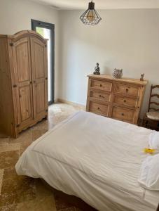 Plan dʼAups的住宿－Chambre d hôtes LA MANDALA，一间卧室配有一张大床和一个木制梳妆台