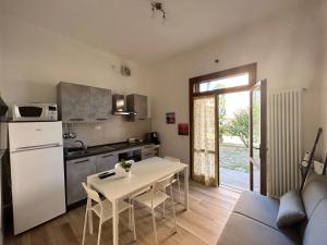 een keuken en een woonkamer met een tafel en een bank bij Sunflowers house in Punta Marina