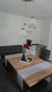 a kitchen with a wooden table with a vase of flowers at Apartment Bachweg in Forstau