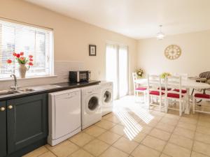a kitchen with a washing machine and a dining room at Owen Tucker View House in Ardara