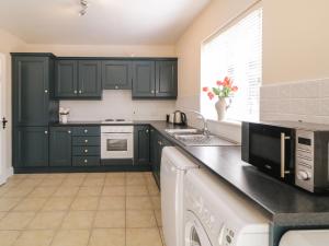 una cucina con armadi verdi scure e lavandino di Owen Tucker View House a Ardara Altre 14 foto