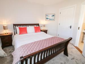 a bedroom with a large bed with red pillows at Owen Tucker View House in Ardara