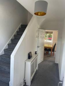 a hallway with a staircase with a door and a table at Whole Apartment Near to London in Bromley