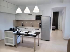 a kitchen with a table and a refrigerator at Crete Apart House - North in Ayía Marína