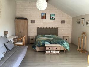 1 dormitorio con cama, sofá y mesa en Chambre d'hôtes Maison des 5 Fleurs, en Heugas