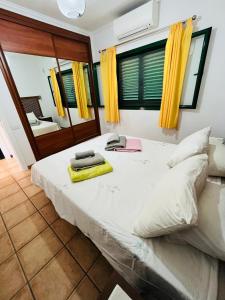 a bedroom with a large white bed with yellow curtains at Playa Park in Puerto del Carmen +15 photos
