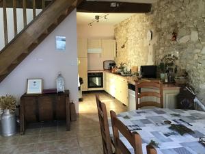 a kitchen and a dining room with a table at Chambre d'hôtes Maison des 5 Fleurs in Heugas