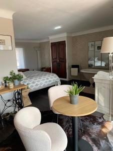 a hotel room with a bed and tables and chairs at Les Trois soleils in Roquebrune-sur-Argens