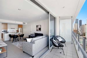 a living room with a couch and a table and a kitchen at Romantic Getaway in Surfers Paradise - Elston Apartment with Ocean View - Wow Stay in Gold Coast