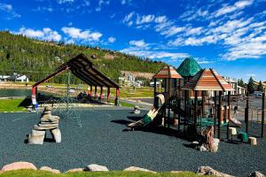 a playground with a slide and swings at Legacy Villa in Brian Head
