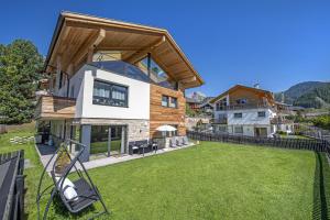 une maison avec une grande pelouse devant dans l'établissement Apartment Villa Valeria, à Selva di Val Gardena