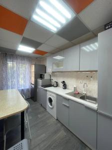 una cocina con fregadero y lavadora en Uneed Rooms Sakvoiaj, en Kiev
