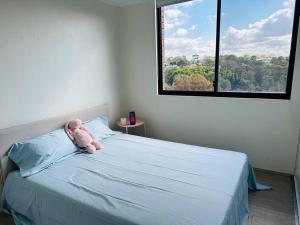 a teddy bear sitting on a bed in a bedroom at Imagine house in Sydney