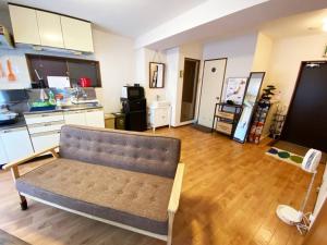 a living room with a couch and a kitchen at 1min walk to sta, drct bus to HND! Easy access! 01 in Tokyo