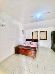 a bedroom with a wooden bed in a room at Guest House Sakura F3 in Karangtengah +20 photos