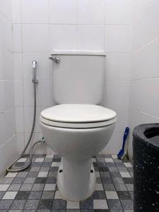 La salle de bains est pourvue de toilettes blanches et d'un tuyau. dans l'établissement Guest House Sakura F3, à Karangtengah