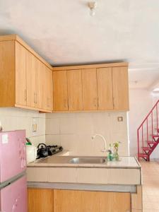Il comprend une cuisine équipée d'un évier et d'un réfrigérateur rose. dans l'établissement Guest House Sakura F3, à Karangtengah
