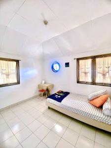 - une chambre avec un lit et une horloge au plafond dans l'établissement Guest House Sakura F3, à Karangtengah