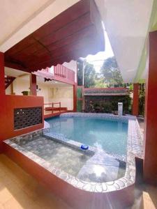 - une grande piscine dans une maison avec un parasol dans l'établissement Guest House Sakura F3, à Karangtengah