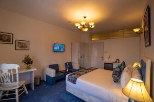 um quarto de hotel com uma cama, uma secretária e uma cadeira em Shinepukur Suites at Concord em Daca