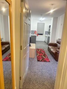 SEV Apartments Wakefield في Hemsworth: ممر يؤدي إلى غرفة معيشة مع أريكة