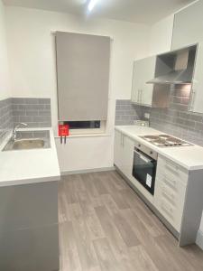 SEV Apartments Wakefield في Hemsworth: مطبخ مع مغسلة وموقد فرن علوي