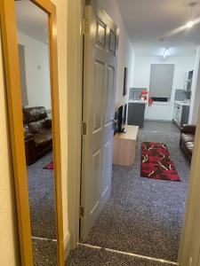 a room with a door and a living room with a couch at SEV Apartments Wakefield in Hemsworth