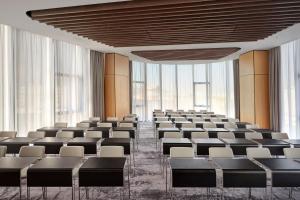 uma sala de conferências vazia com cadeiras e janelas grandes em AC Hotel by Marriott Split em Split