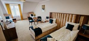 a bedroom with two beds and a table and chairs at Pensjonat Miedziana Perła LUBIN in Lubin