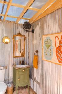 a bathroom with a green sink and a toilet at Camposanto Glamping - The Macaw Yurt in Austin