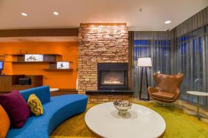 a living room with a blue couch and a fireplace at Fairfield Inn & Suites by Marriott Provo Orem in Orem