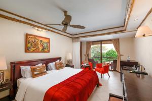 um quarto com uma cama grande e um cobertor vermelho em Chobe Safari Lodge em Kamdini