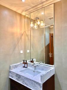 La salle de bains est pourvue d'un lavabo en marbre et d'un miroir. dans l'établissement AL JUNAIDI FARM BY BRIDGE RETREATS, à Charjah