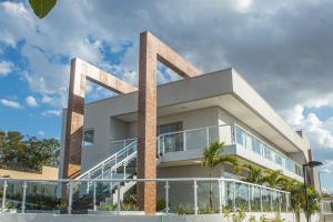 卡爾達斯諾瓦斯的住宿－Casa Jardins da Lagoa，带阳台的白色建筑,棕榈树