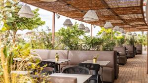 een restaurant met tafels, stoelen en planten bij Seth Port Ciutadella in Ciutadella