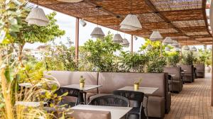un restaurante con mesas, sillas y plantas en Seth Port Ciutadella, en Ciutadella