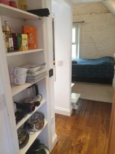a room with a closet with shelves and a bed at Mezzanine studio apartment (U9) in London
