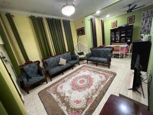 a living room with couches and a rug at DZ’S Homestay in Machang