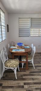 una mesa de comedor con sillas blancas y un tazón azul. en Casa LOLO on hills of Culebra, en Culebra