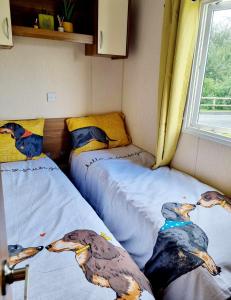 two beds in a room with two birds on them at Eden Breaks, Mallard Lake in Cirencester
